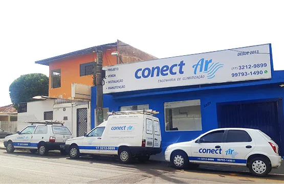 Fachada da Conect Ar em São José do Rio Preto, com letreiro azul, a marcação "DESDE 2013", os telefones (17) 3212-9899 e 99793-1490 e três veículos de serviço da empresa estacionados na frente